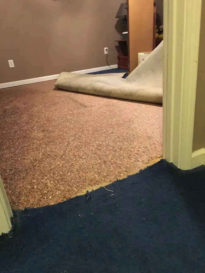 Carpet pad removal revealing water damage during Water Mitigation Services in Hudson Falls